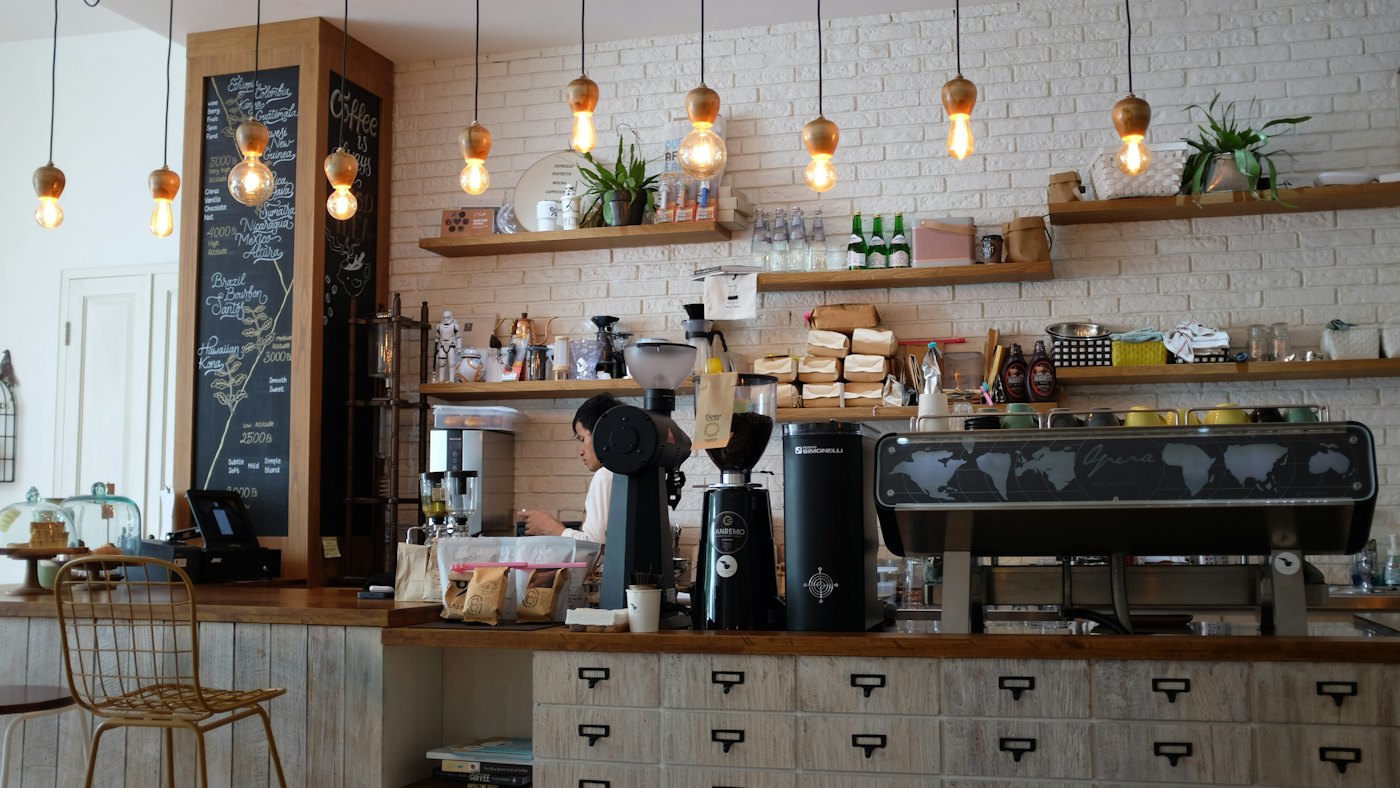 A barista working the espresso machine behind the Household Coffee counter